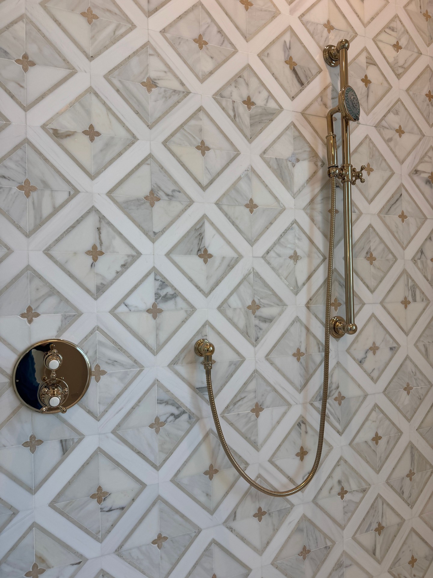 A closer look at the craftsmanship. This custom marble tile shower brings together soft veining, beautiful detailing, and warm brass fixtures to create a truly elevated space in @watersoundorigins.